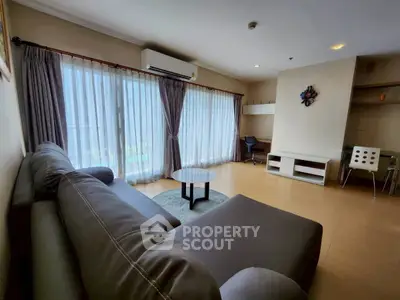 Spacious living room with modern furniture and large windows offering natural light.
