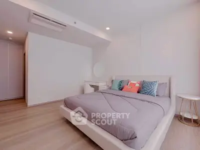 Modern bedroom with stylish decor and cozy bedding in a contemporary apartment.