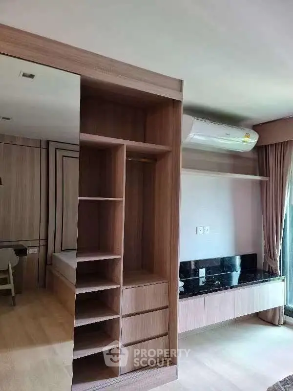 Modern bedroom with built-in wooden wardrobe and sleek air conditioning unit.