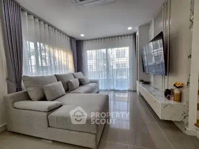 Spacious modern living room with large windows and sleek furniture