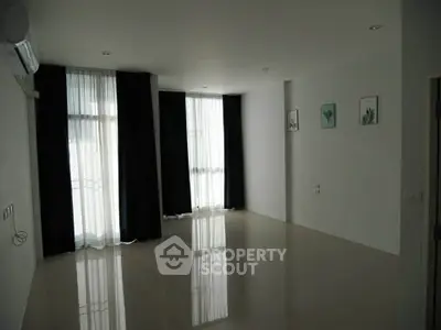 Spacious empty living room with large windows and modern decor, perfect for customization.