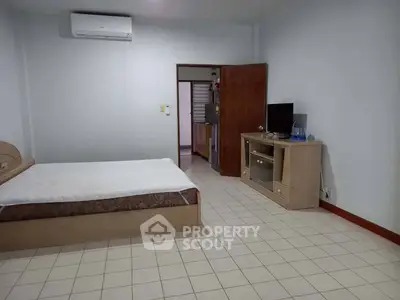 Spacious bedroom with modern amenities and open access to kitchen area