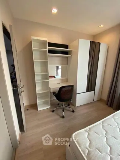 Modern bedroom with study area, featuring sleek furniture and ample natural light.