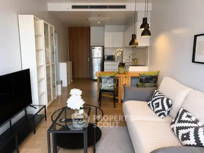 Modern living room with stylish decor and open kitchen layout in a cozy apartment.