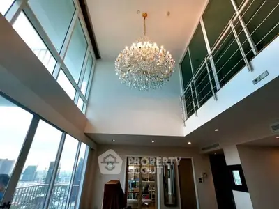 Luxurious high-ceiling living room with chandelier and city view