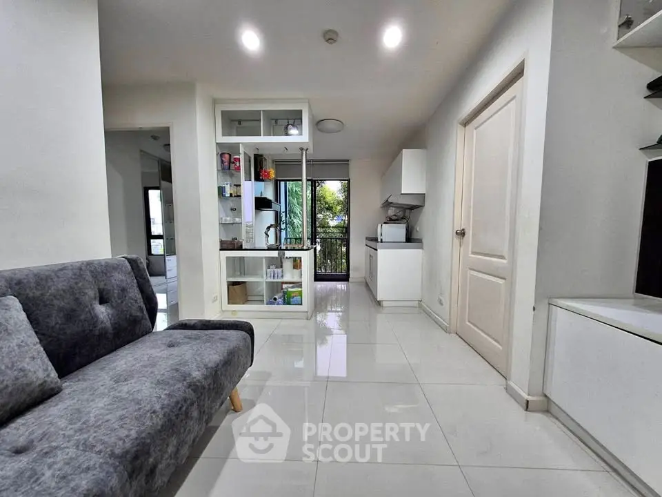 Modern living room with sleek design and open layout, featuring a cozy gray sofa and bright natural lighting.
