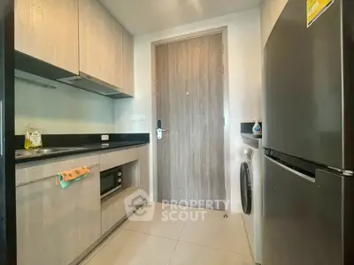 Modern kitchen with sleek appliances and wooden cabinetry in a stylish apartment.