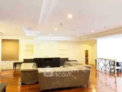 Spacious living room with modern furniture and elegant wooden flooring.