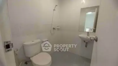 Spacious bathroom with modern fixtures and white tiles