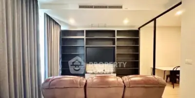 Spacious living room with modern shelving and cozy seating, perfect for relaxation and entertainment.