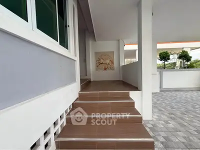 Modern building entrance with tiled steps and decorative wall art, offering a welcoming ambiance.
