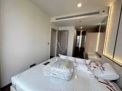 Modern bedroom with stylish decor and ample natural light, featuring a cozy bed and sleek furnishings.