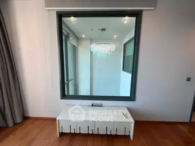 Modern interior with large window and elegant chandelier reflection