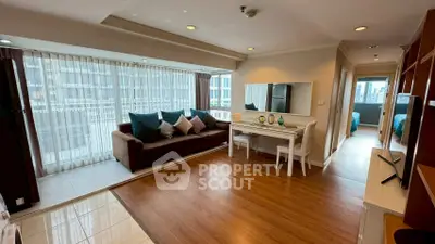 Spacious living room with large windows and modern decor in a city apartment.