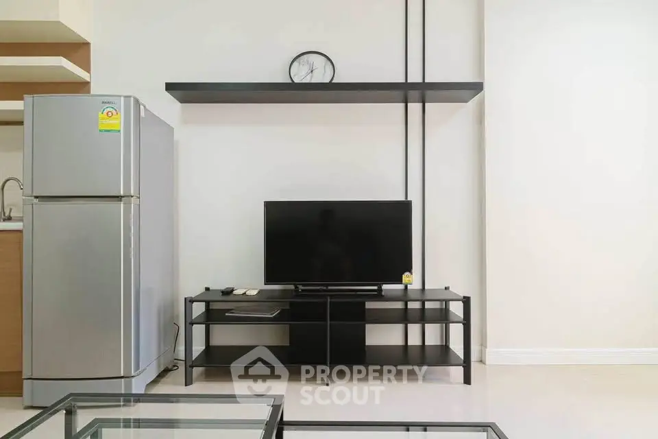 Modern living room with sleek TV stand and stainless steel fridge, perfect for contemporary urban living.