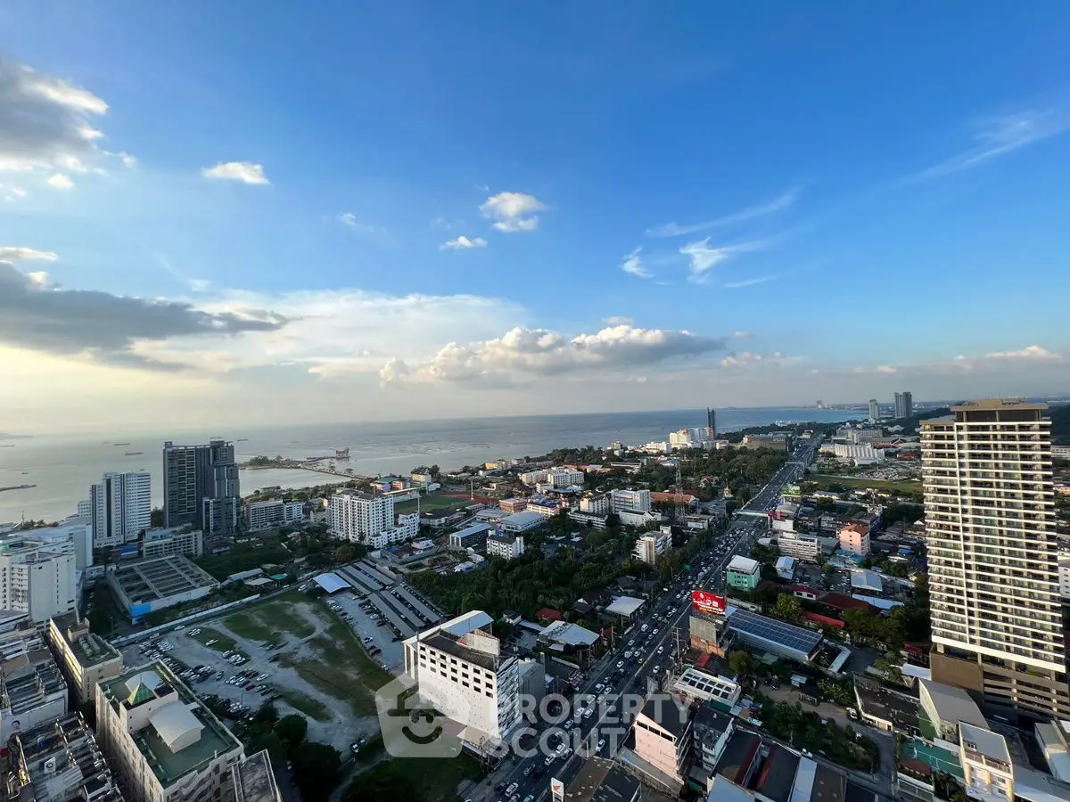 Stunning cityscape with ocean view from high-rise building, showcasing urban living and coastal beauty.