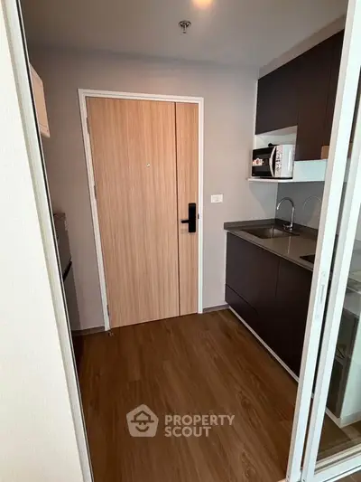 Modern kitchen with sleek cabinetry and wood flooring in a stylish apartment.