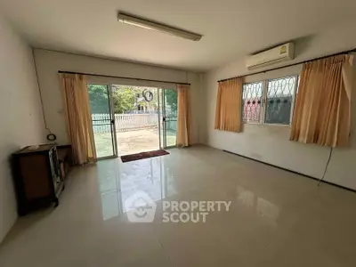 Spacious unfurnished living room with large window and garden view