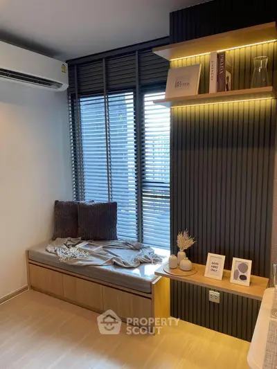 Modern living room with cozy seating and stylish decor, featuring natural light and elegant shelving.