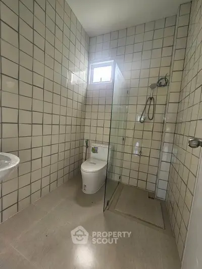 Modern minimalist bathroom with tiled walls and glass shower enclosure