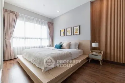Modern bedroom with stylish decor and natural light, featuring a cozy bed and elegant wooden flooring.