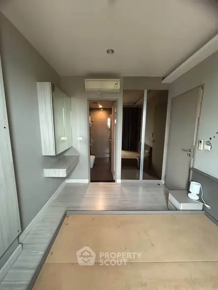 Modern minimalist bedroom with ensuite bathroom and air conditioning in stylish apartment.
