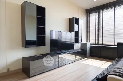Modern living room with sleek TV unit and large windows for natural light.