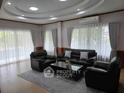 Spacious living room with elegant leather sofas and large windows