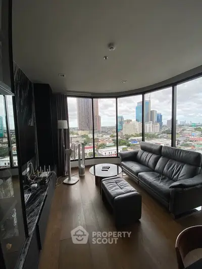 Luxurious living room with panoramic city views and modern leather furniture.