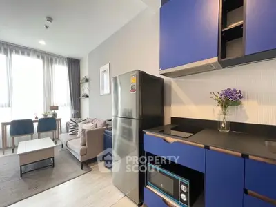 Modern living room and kitchen with blue cabinets and stainless steel appliances