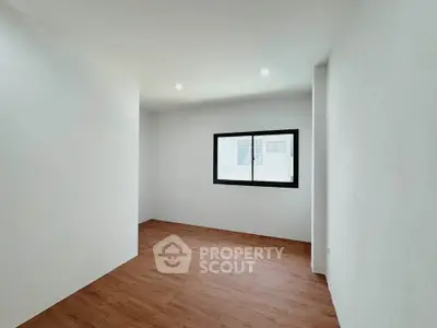 Spacious minimalist room with wooden flooring and natural light