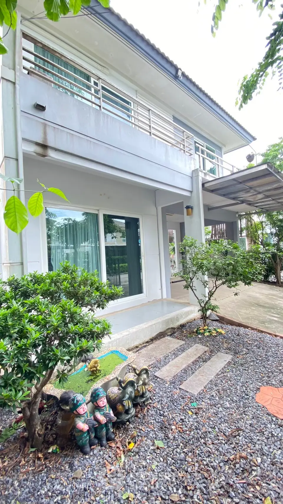 Charming two-story house with lush garden and modern exterior design.