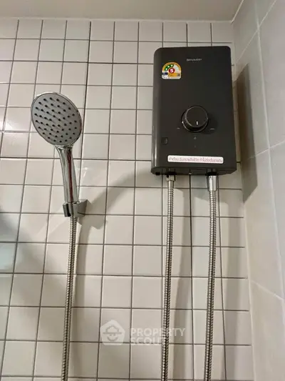 Modern bathroom with sleek showerhead and efficient water heater on tiled wall.