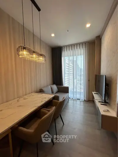 Modern living room with elegant lighting, marble dining table, and floor-to-ceiling windows offering city views.