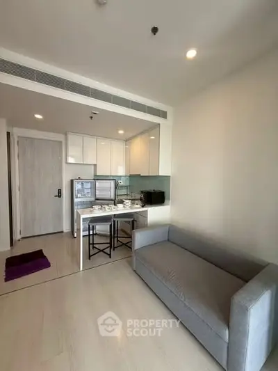 Modern apartment interior with cozy living area and compact kitchen, perfect for urban living.