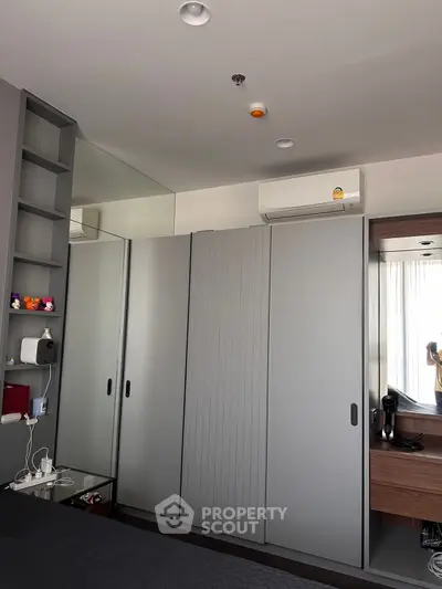 Modern bedroom with sleek wardrobe and air conditioning unit