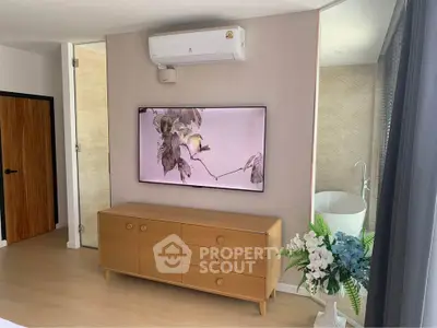 Modern bedroom with wall-mounted TV, air conditioning, and elegant decor