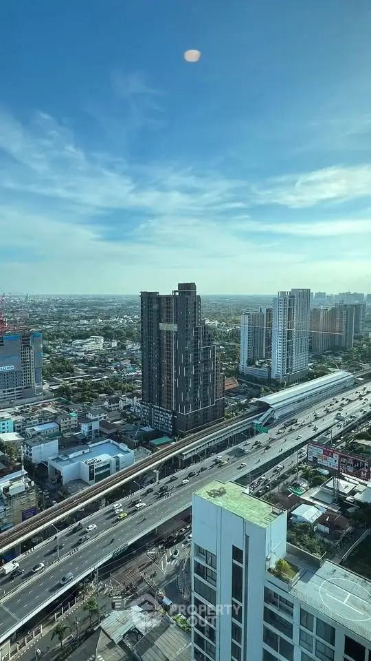 Stunning cityscape view from high-rise building with clear blue sky and bustling highway below.