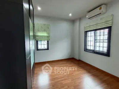 Spacious empty room with wooden flooring and air conditioning, perfect for customization.