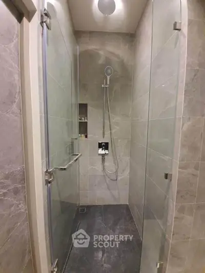 Modern bathroom with sleek glass shower and elegant marble tiles