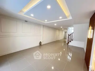 Spacious modern interior with elegant ceiling lights and glossy tiled flooring, perfect for versatile living space.