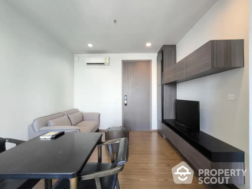 Modern living room with sleek furniture and wooden flooring in a stylish apartment.