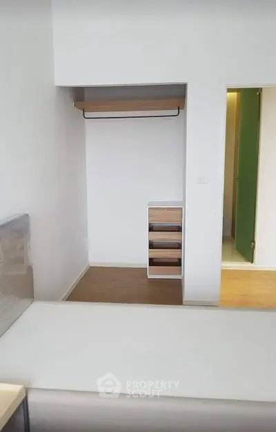 Modern minimalist bedroom with open closet and wooden flooring