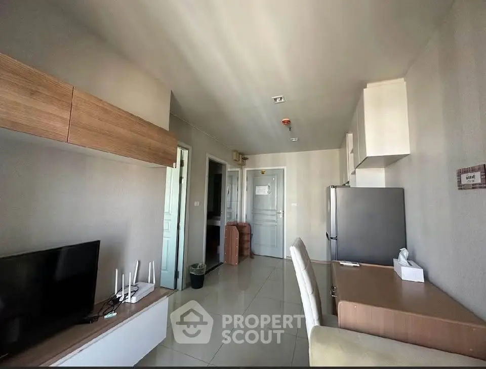 Modern living room with sleek furniture and open layout, featuring a TV and stylish decor.