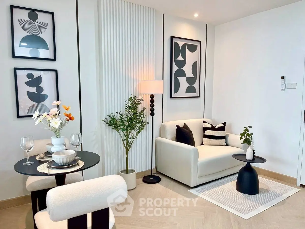 Modern living room with stylish decor and dining area, featuring abstract art and cozy seating.