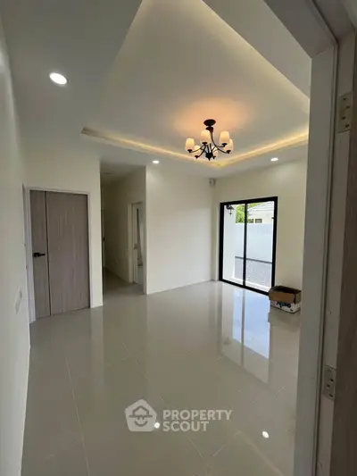 Spacious modern living room with elegant lighting and large windows for natural light.