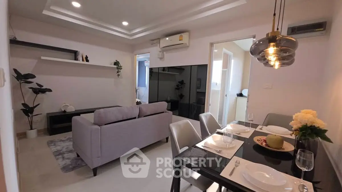 Modern living room with dining area, sleek furniture, and elegant lighting