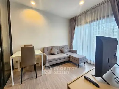 Modern living room with cozy sofa, dining table, and large window with sheer curtains.