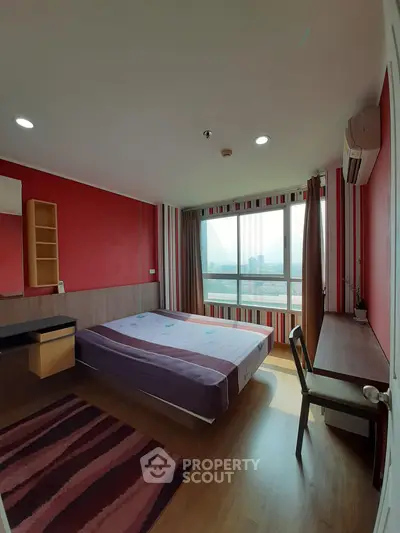 Spacious bedroom with city view, modern decor, and ample natural light in a high-rise apartment.