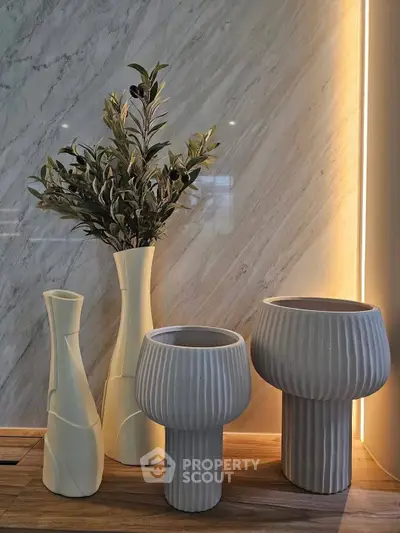 Elegant interior decor with modern vases and ambient lighting on a wooden surface.